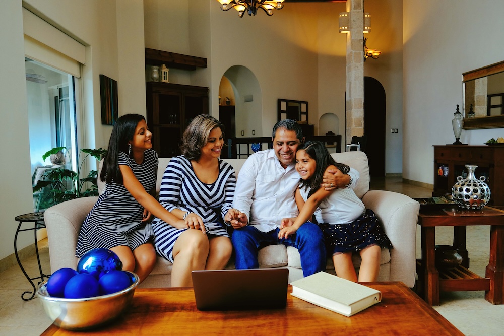 Happy Man Embracing Daughter While Sitting With Family